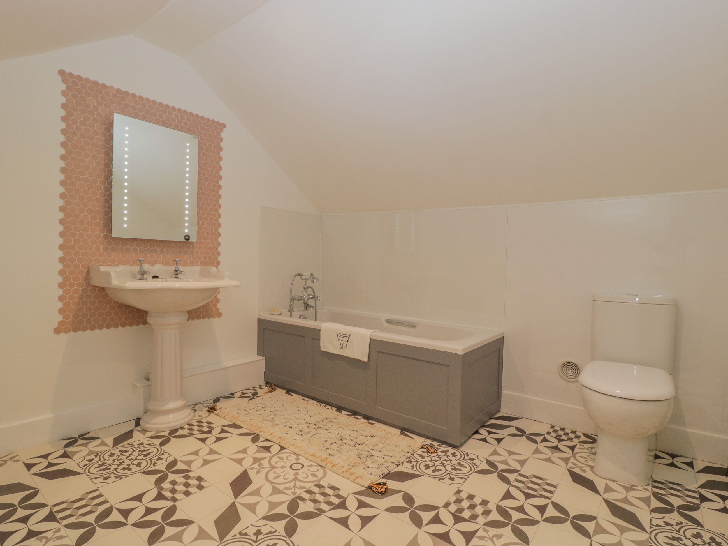 A bathroom with a white sink, a bathtub, and a toilet.