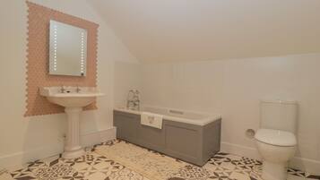 A bathroom with a white sink, a bathtub, and a toilet.