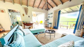 A spacious living area with a large sofa set, a coffee table, and a view of the outdoors. - Chambre dans Villa Casa Blue, piscine, vue mer (Cole Bay)