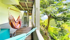 A balcony with a hammock, wooden deck, and a view of lush greenery. - Chambre dans Villa Casa Blue, piscine, vue mer (Cole Bay)