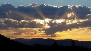 La silhouette d’une chaîne de montagnes au coucher du soleil, avec des nuages.
