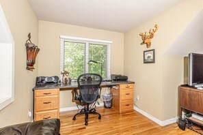 Work and unwind in a functional office space with a desk, chair, and TV.