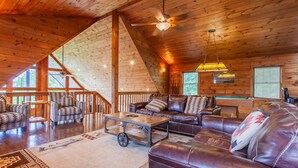 A cozy cabin interior with a wooden ceiling, a fireplace, leather sofas, and a billiards table. - A Walk in the Clouds (Bryson City)