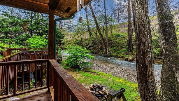 Una terraza de madera con vistas a un río y vegetación circundante.