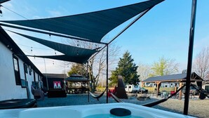 A hot tub area with a canopy, a slide, and a pool. - The Bike Inn #4, Centennial Park, Single Room (Bentonville)