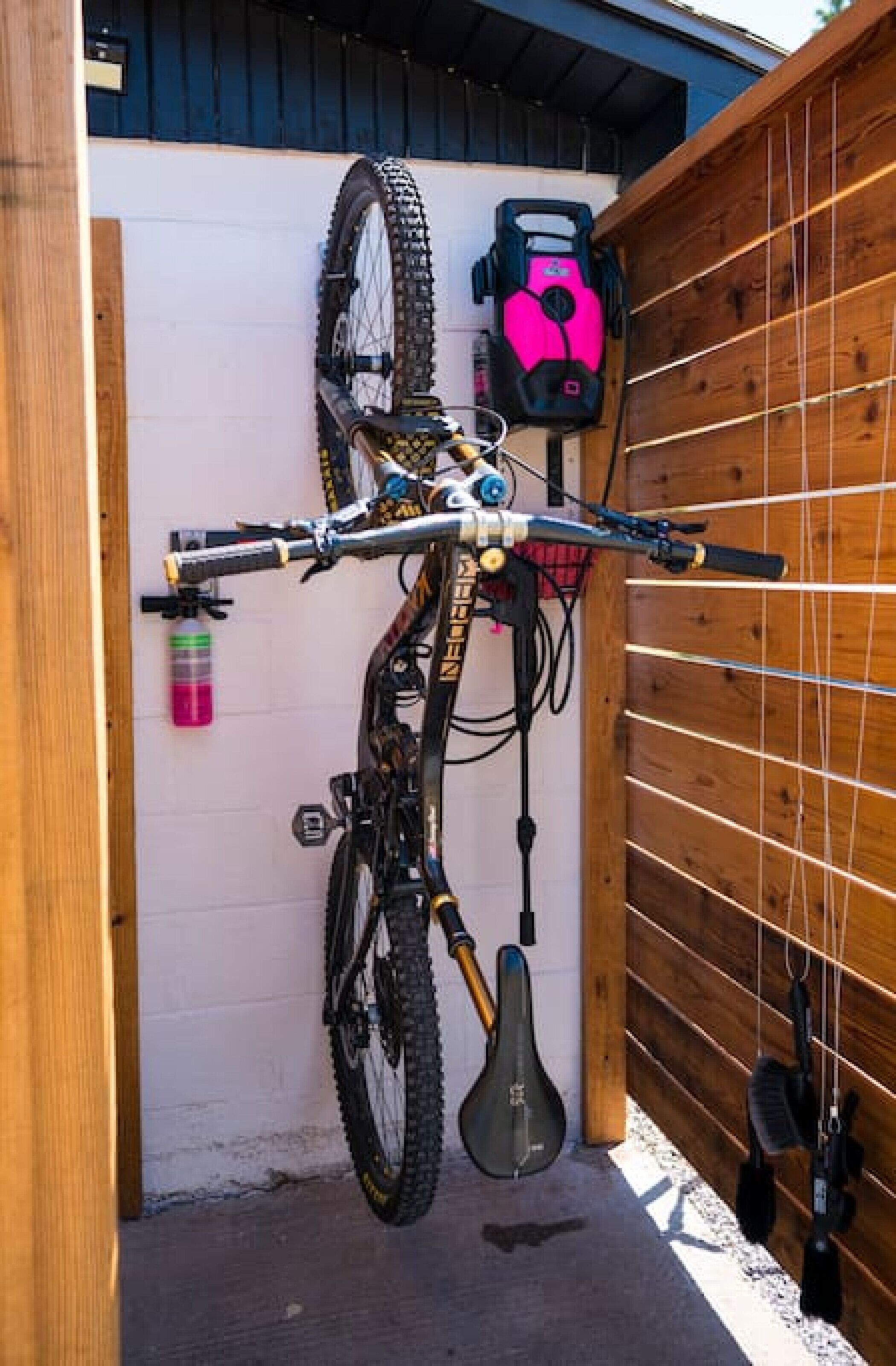 A bicycle mounted on a wall with a helmet and a water bottle nearby.