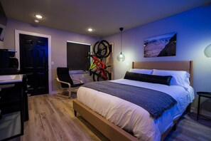 A modern bedroom with a bed, a desk, and a bicycle mounted on the wall.