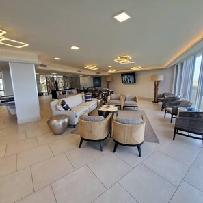 A spacious living area with a sofa, chairs, a coffee table, and a dining table.