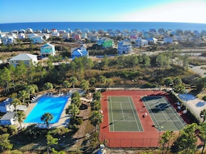 Zona residencial com piscina, quadras de tênis e casas com vista para o oceano.
