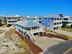 A coastal residential area with houses featuring balconies and a clear sky.