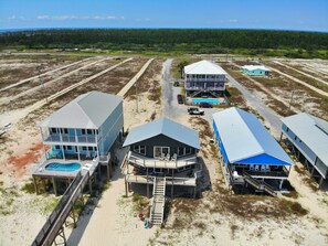 A coastal property with multiple buildings, including a large house with a pool and a smaller structure with a balcony.