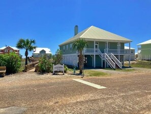 A two-story building with a balcony and a staircase leading to the entrance. - Great views and next to boardwalk! (Gulf Shores)