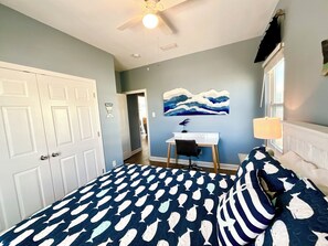 A bedroom with a bed featuring a fish pattern, a desk with a chair, a ceiling fan, and a painting on the wall. - Great views and next to boardwalk! (Gulf Shores)