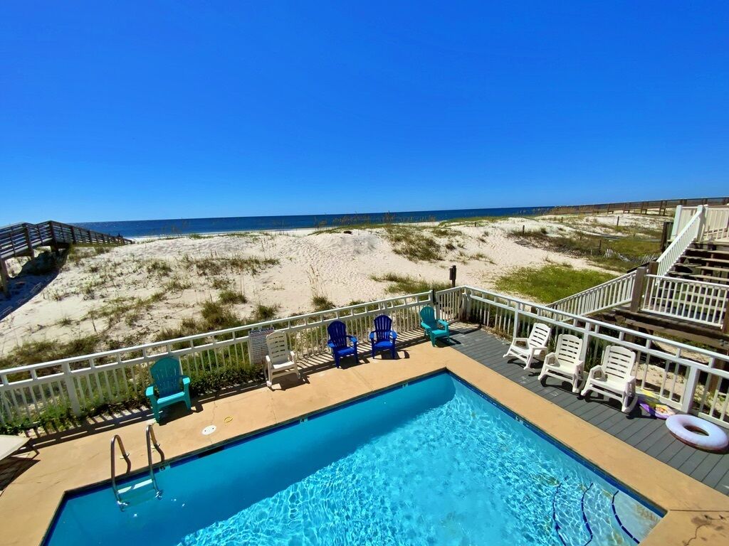 A swimming pool with a view of the beach and ocean.