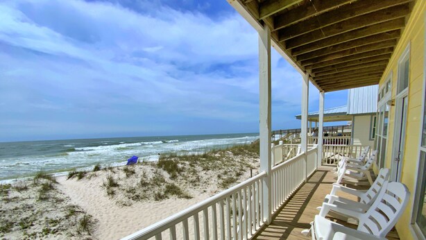 A beachside porch with white chairs and a view of the ocean. - Beachfront w/ 2 living areas!  Great Location! (Gulf Shores)