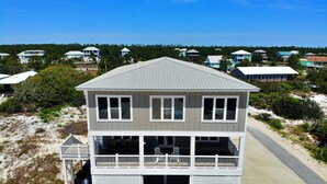 A two-story beach house with a balcony and a garage. - Shared Private Beach Walk, Pools & Pickleball (Gulf Shores)