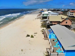 A beachside property with multiple buildings, some with elevated structures, and a sandy beach. - Beachfront & Dog Friendly! (Gulf Shores)