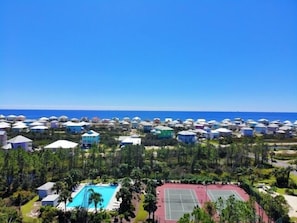 A resort with multiple dome-shaped cabins, a swimming pool, and tennis courts.