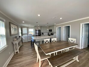 A modern kitchen with white cabinets, a central island, and pendant lighting. - Modern, Beachfront & Pet Friendly (Gulf Shores)