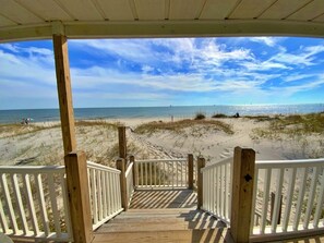 A wooden deck leading to a beach with a clear view of the ocean and sky. - Beachfront in Fort Morgan!  Pets ok! (Gulf Shores)