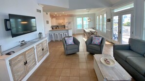 A spacious living area with a flat-screen TV, a dining table with chairs, and a sofa. - Great Gulf Views & Pools, Pickleball (Gulf Shores)