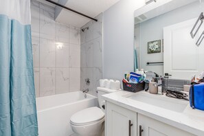 Ein modernes Badezimmer mit Badewanne, Toilette und Waschbecken.