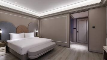 A modern bedroom with a large bed, bedside tables, and a walk-in closet.