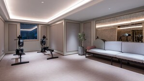 Une chambre d’hôtel moderne dotée d’un espace pour faire de l’exercice, d’un canapé et d’une grande fenêtre offrant une belle vue.