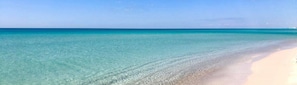 Una playa con agua turquesa cristalina y una orilla arenosa.