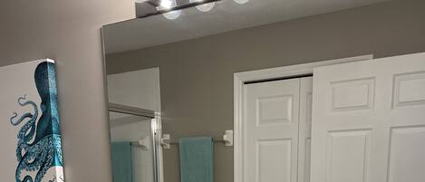 A bathroom with two sinks, a large mirror, and a towel rack.