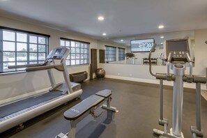 Ett gym med löpband, en crosstrainer och en roddmaskin.