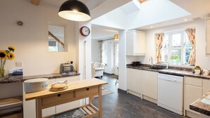A modern kitchen with a skylight, wooden table, and a view of the adjacent living area. - 3 bedroom accommodation in Forden (Forden)
