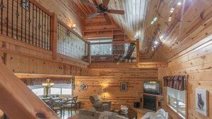 A spacious cabin with a dining area, living room, and a balcony.