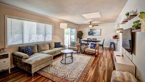 A modern living room with a sofa, coffee table, and dining area.
