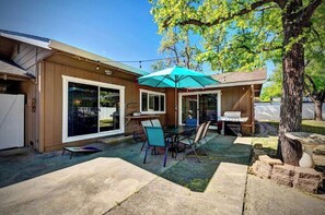 Enjoy al fresco dining and outdoor cooking in this patio area, complete with a table, chairs, and grill.