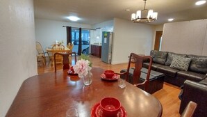 A dining area with a wooden table, chairs, and a vase with flowers.