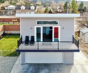 A modern single-story house with a covered patio, a garage, and a view of the surrounding neighborhood.
