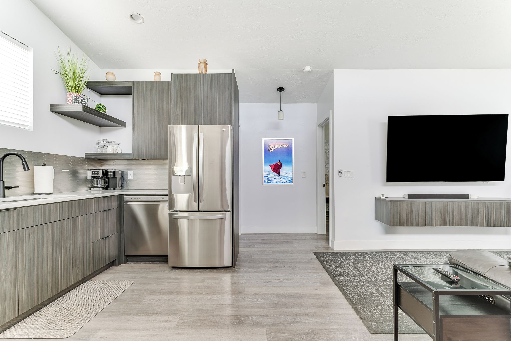 Una cocina moderna con refrigerador de acero inoxidable, armarios de madera y horno empotrado.