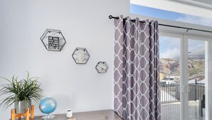 A room with a wooden desk, a globe, a potted plant, and hexagonal wall art. - The Fortress (Cedar City)