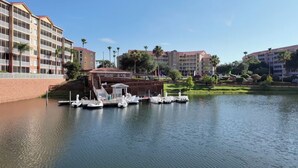 A marina with boats docked, a building with a red roof, and palm trees in the background. - Westgate Orlando Deluxe Villa, 4 Bedroom, 16 max occupancy (Kissimmee)