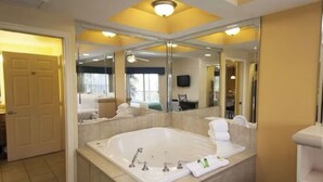 A spacious bathroom with a large bathtub, a mirror, and a door leading to another room. - Westgate Orlando Deluxe Villa, 4 Bedroom, 16 max occupancy (Kissimmee)