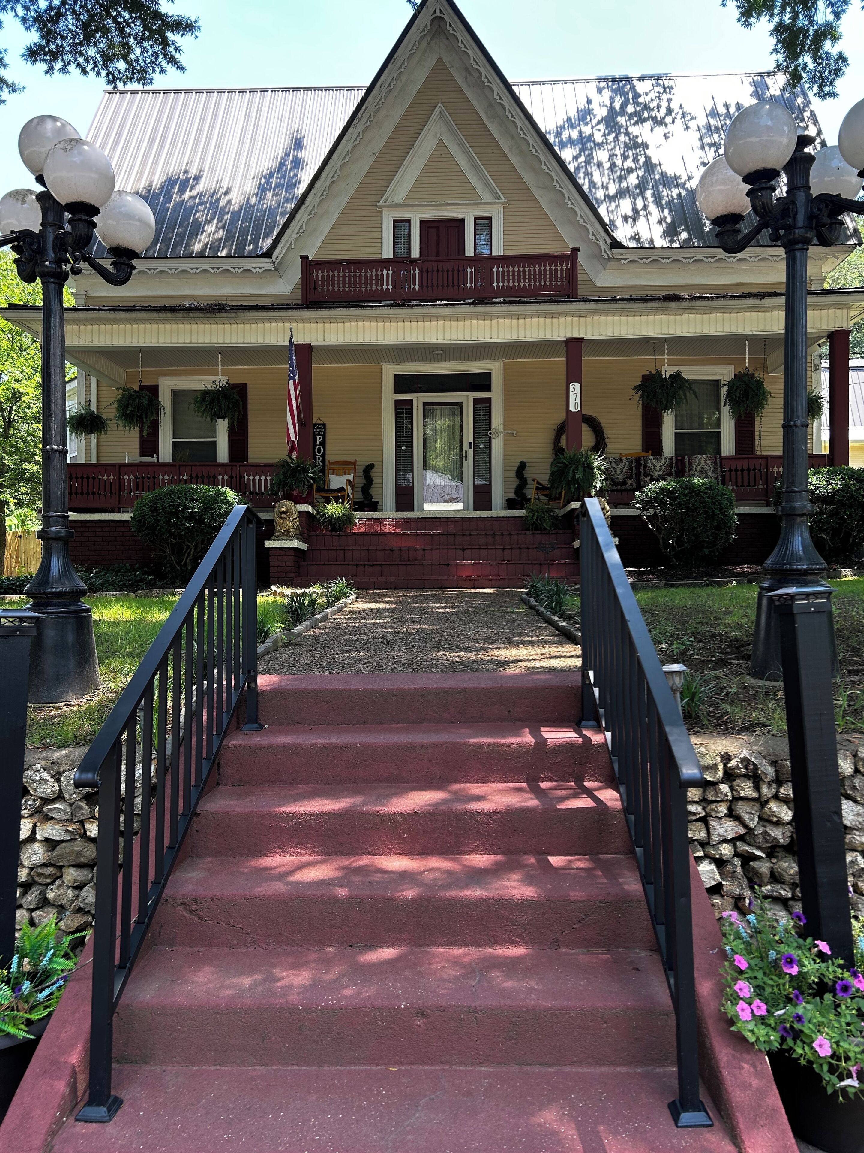A two-story building with a front porch, a flag, and a sign indicating the number 35.