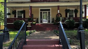 A two-story building with a front porch, a flag, and a sign indicating the number 35. - Experience Charleston charm near Hiwassee River (Charleston)