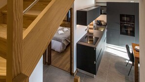 A modern kitchen with dark cabinetry and a built-in oven.