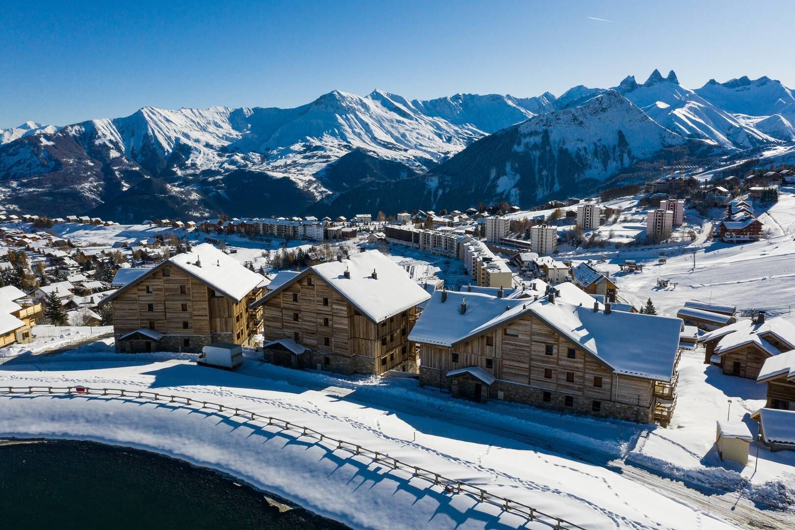 A snow-covered mountain town with wooden buildings and a ski slope.