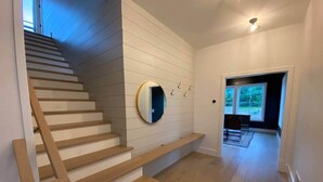 A staircase with wooden steps and a wall-mounted mirror. - Ellison Bay Family Retreat! 8 bed/6 bath/20 acres (Ellison Bay)