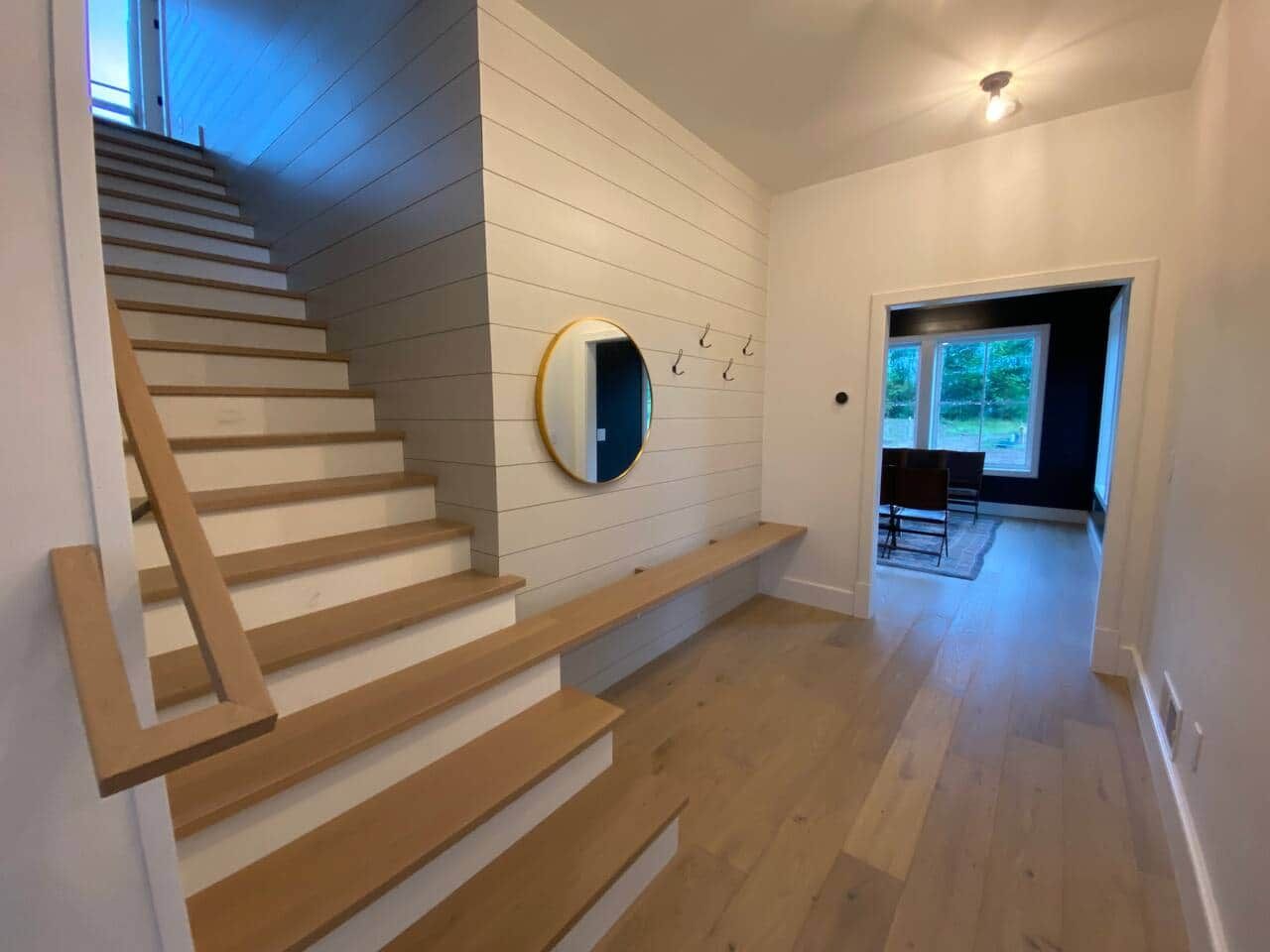 Een trap met houten treden en een spiegel aan de muur.