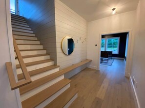 Un escalier avec des marches en bois et un miroir fixé au mur.