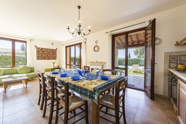 Un coin repas avec une table dressée pour quatre personnes, entourée de chaises en bois.