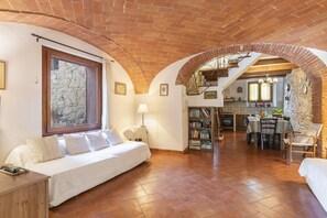Una habitación acogedora con cama, ventana, escalera y zona de cocina.